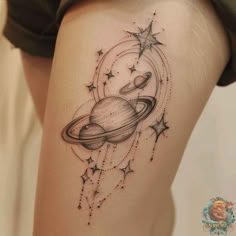 a woman's thigh with an saturn tattoo on it and stars in the background