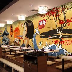 a restaurant with an artistic mural on the wall next to benches and tables in front of them