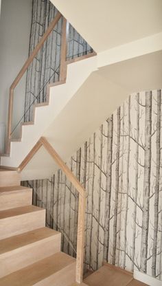 the stairs are lined with wallpaper and wooden handrails