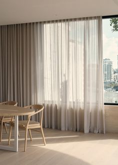 a dining room table and chairs in front of a large window with cityscape