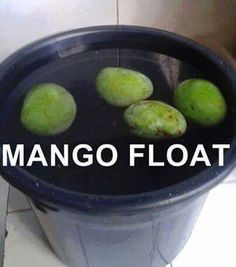 a bucket filled with green fruit sitting on top of a tiled floor