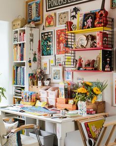 a desk with many books and pictures on the wall