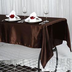 the table is set for two with wine glasses and napkins on it, ready to be served