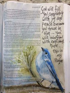 an open bible with a painting of a blue bird on it's page and the words, god will fill you completely with joy and peace because you trust in him