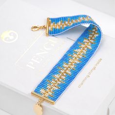 a blue and gold beaded lanyard on a white box