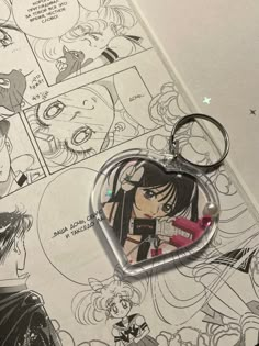 a heart shaped keychain with an anime character on it's front and back sides