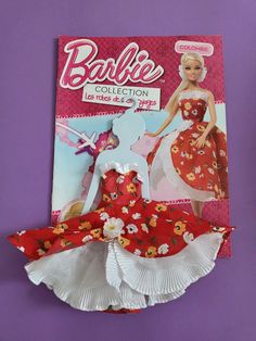 the barbie doll is wearing a red and white dress with flowers on it's skirt