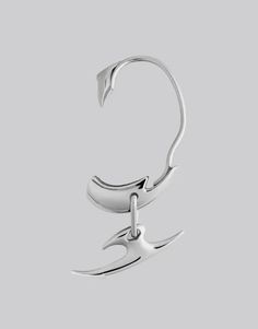 a pair of scissors hanging from the end of a hook on a gray background,