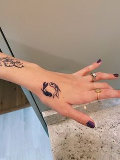 a woman's hand with tattoos on it