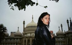 a woman standing in front of a building with domes on it's roof tops