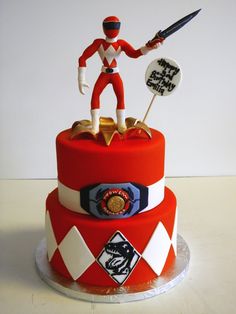 a red and white cake with a man holding a knife on it's top