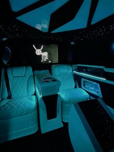 the interior of a car with blue lights and black leather seats, including an entertainment center