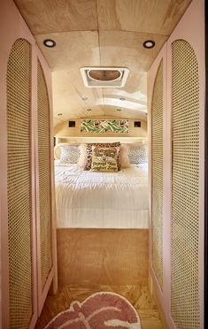 a bed sitting inside of a bedroom on top of a wooden floor next to a window