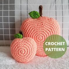 two crocheted pumpkins sitting next to each other