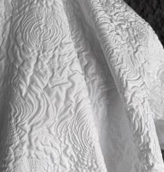 white quilted bedspread on top of each other with black and white background