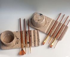 a set of brushes and bowls sitting on top of a table next to each other