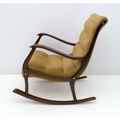 a wooden rocking chair with tan upholstered fabric on the back and seat cushion