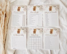 four baby shower games laid out on top of a white sheet with dried grass in the background