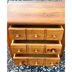 a wooden dresser with three drawers on it