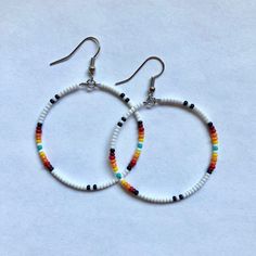 These handmade, beaded hoop, earrings come in a variety of colors. This is a gorgeous white sunset pattern. Perfect for all occasions and super comfortable to wear. These earrings are not heavy at all and can be worn comfortably all day. The earrings are 5 cm across. Every pair is unique and  may look somewhat different than the picture. I love making these earrings and hope you enjoy wearing them! Handmade White Heishi Beads Earrings, Bohemian White Hoop Earrings For Beach, Handmade Heishi Beads Earrings, Festival Colorful Beaded White Hoop Earrings, Festival White Hoop Earrings With Colorful Beads, White Round Hoop Earrings For Festival, Bohemian Heishi Beads Hoop Earrings, Bohemian Heishi Beaded Hoop Earrings, Bohemian Hoop Beaded Earrings With Heishi Beads