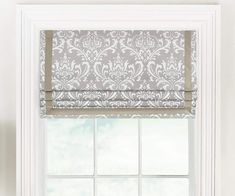 a window with a white and gray roman blind