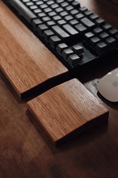 a computer keyboard and mouse on a wooden desk