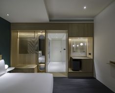 a hotel room with a bed, desk and mirror