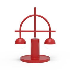 a red table lamp with two lights on each side and an object in the middle