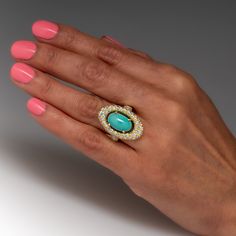 This captivating turquoise ring is centered with an oval turquoise cabochon, weighing an estimated 4.62 carats, in a four-prong setting. The center is surrounded by a halo, bead set with fifty-four (54) round brilliant cut diamonds. The shoulders are each bead set with ten (10) round brilliant cut diamonds. The ring measures 26.4mm at the top, rises 8.5mm above the finger, tapering to 2.4mm wide and 1.0mm thick at the base of the shank. The ring is currently a size 6. Luxury Oval Turquoise Ring With Polished Finish, Luxury Artisan Turquoise Oval Ring, Luxury Yellow Gold Turquoise Ring, Oval Cabochon, Luxury Yellow Gold Turquoise Ring With Accent Stones, Luxury Gold Turquoise Ring In Vintage Style, Luxury Turquoise Oval Cabochon Ring, Luxury Oval Turquoise Ring, Luxury Turquoise Cabochon Ring, Luxury Oval Turquoise Gemstone Ring