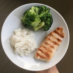 a white plate topped with meat, rice and broccoli