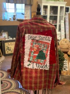 a red and green plaid jacket with santa on it