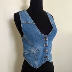 You'll Feel On-Trend Wearing This Women's Denim Vest By A.N.A As A Layering Piece. Crafted From A Structured Recycled Denim Blend With A Hint Of Stretch, This Sleeveless Cropped Vest Has A Button-Front Closure And Side Slip Pockets. Wear It On Its Own With Wide-Leg Pants Or Jeans Or Over A Fitted Baby Tee. Strap Type: Adjustable Closure Type: Button Fit: Regular Fit Neckline: V Neck Pockets: 2 Front Slip Pockets Sleeve Length: Sleeveless Apparel Length: 20 Inches - Front Fiber Content: 94% Cotto Fitted Denim Blue Casual Top, Fitted Casual Denim Jacket In Recycled Denim, Fitted Washed Denim Vest, Fitted Dark Wash Denim Top With Pockets, Fitted Blue Denim Top From Recycled Material, Fitted Casual Denim Vest In Medium Wash, Fitted Blue Recycled Denim Top, Trendy Fitted Washed Blue Denim Vest, Fitted Dark Wash Denim Top