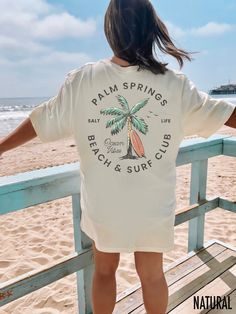 Dive into coastal vibes with our Palm Springs Beach & Surf Shop t-shirt.  We use professional quality DGT printing on all our apparel. Direct-to-garment, or DTG, is a high quality printing method that sprays ink directly onto the garment so there is no peeling or cracking. This fabulous graphic will be printed on a Bella+Canvas Unisex Tee. Order your regular size for a slim fit and size up for an oversized fit. Please refer to the size charts in the images to find your ideal fit.  Production Time: 1-5 days Shipping Time: 2-5 days Machine wash: cold  Non-chlorine: bleach as needed Tumble dry: low heat Iron, steam or dry: medium heat Do not dry clean Beach House Logo, Beach Tees, Summer Shopping List, Y2k Tshirt, Spring T Shirts, Beach Tee, Surf Tee, Retro Beach, House Logo