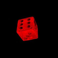 two red dices sitting on top of each other in the middle of a black background