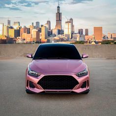 a pink car parked in front of a city skyline