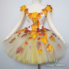 a mannequin dressed in a dress made out of autumn leaves and other things