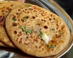 three flat breads with cheese and herbs on a plate