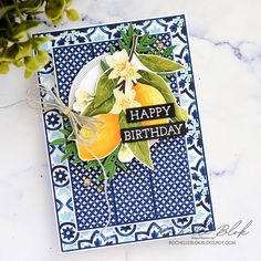 a close up of a birthday card on a marble surface with flowers and greenery