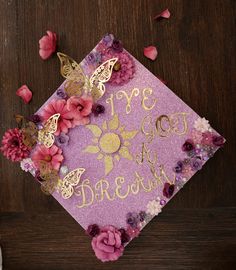 a purple graduation cap decorated with flowers and butterflies