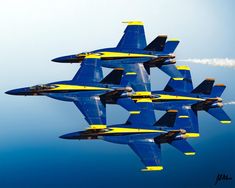 four blue and yellow fighter jets flying in formation