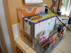 an organized desk with magazines, pens and pencils