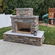 an outdoor fireplace with a slide in the background