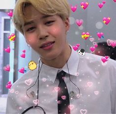 the young man is wearing a tie with hearts all over him and smiling at the camera