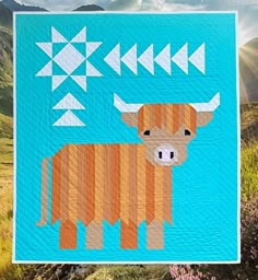 a blue quilt with an image of a brown cow and arrows on it's side