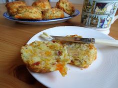 a muffin on a plate next to a cup of coffee with a knife in it