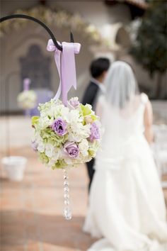 the bride and groom are walking down the aisle with their wedding bouquet hanging from them