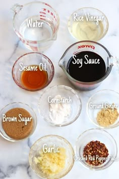 the ingredients for homemade soy sauce in small bowls on a marble countertop, labeled with names