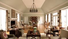 a living room filled with lots of furniture and a chandelier hanging from the ceiling