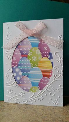 a card with an easter egg design on it and a pink ribbon around the edge