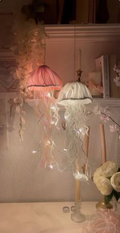 a table topped with a lamp next to a vase filled with white flowers and candles